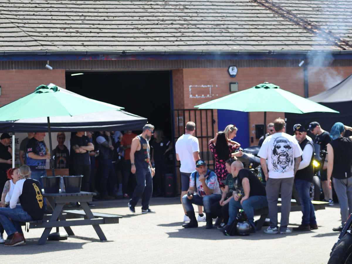 Opening party guests enjoying the courtyard outside the workshop.