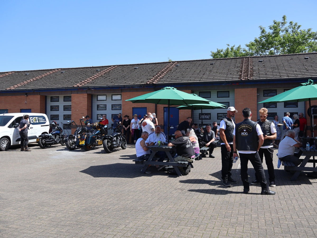 Riders gathered in the courtyard with parked motorcycles.