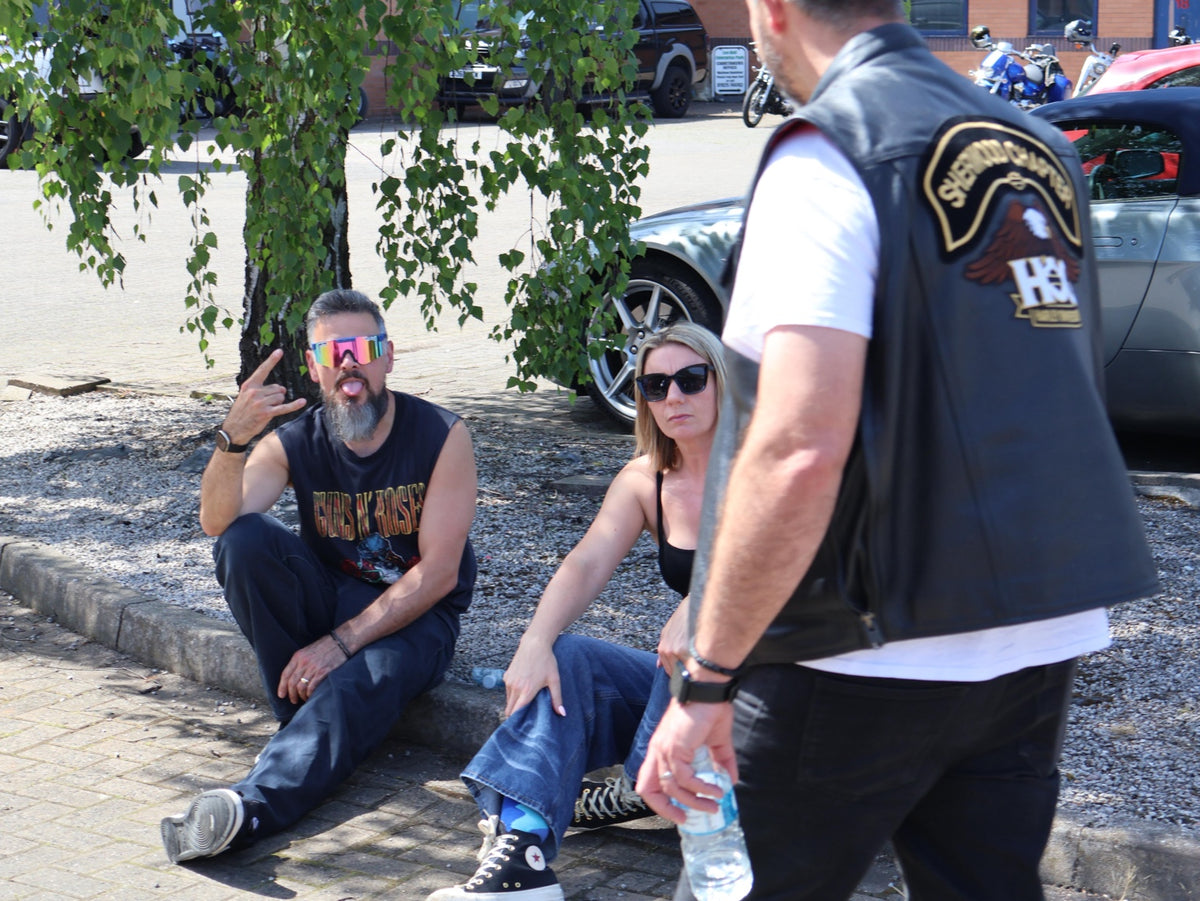 Event guests relaxing and chatting beneath a tree.