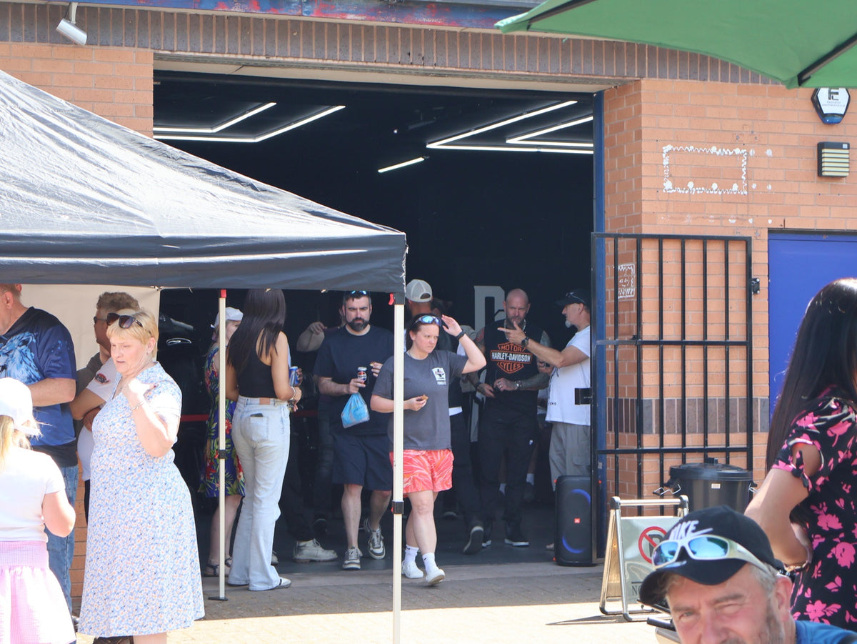 Opening party guests gathered around the workshop entrance.