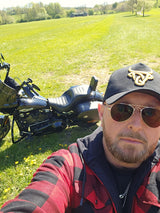 James beside his Harley-Davidson in the countryside.